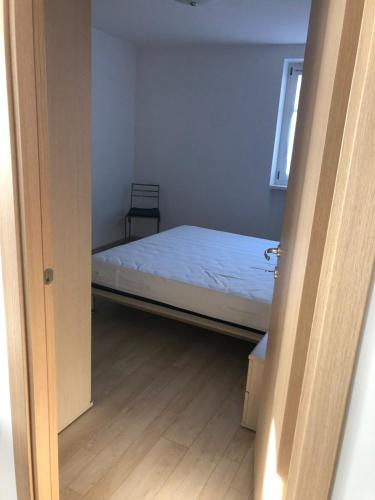 a small bedroom with a bed and a window at Moderno appartamento e ampio garage in centro in Folgaria