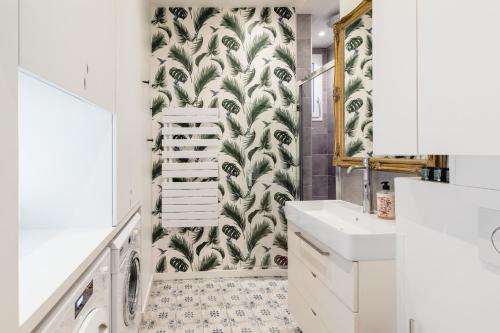 La salle de bains est pourvue d'un lavabo blanc et d'un papier peint vert et blanc. dans l'établissement Luxury 1 BR apartment 700ft2 Montorgueil/LesHalles, à Paris