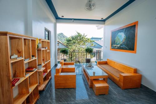 a living room with wooden benches and a table at Green Riverside Cosy Home in Bố Trạch