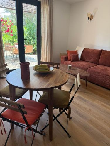 a living room with a table and chairs and a couch at Petite maison cocooning classée 3 étoiles à Bormes les mimosas in Bormes-les-Mimosas