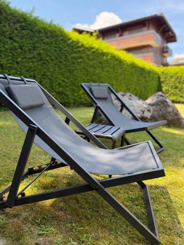 two empty lounge chairs sitting on the grass at Hotel Bel'alpe in Morzine