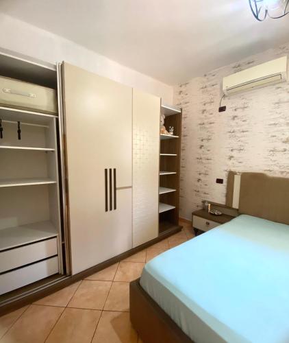 a bedroom with white cabinets and a bed in it at At-Salaj1 in Vlorë