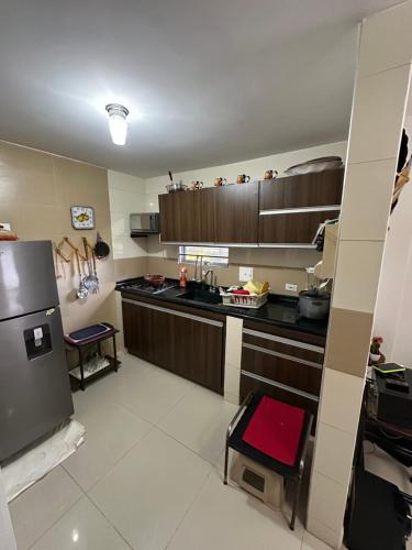 a kitchen with wooden cabinets and a refrigerator at Casa en Marinilla cerca a guatape y el peñol in Marinilla