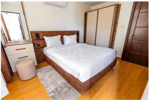 a bedroom with a large bed with a wooden headboard at Cascadia Hotel Apartments by GF Greenland in Kigali