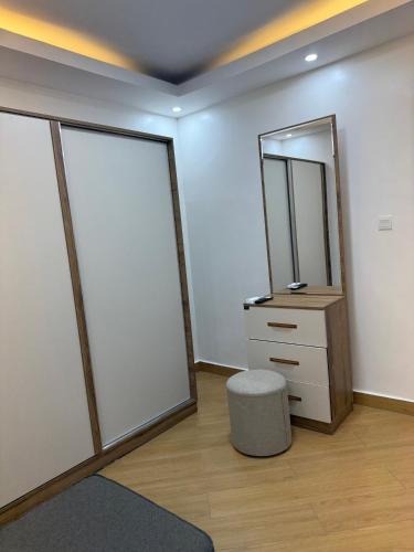 a dressing room with a mirror and a stool at Cascadia Hotel Apartments by GF Greenland in Kigali