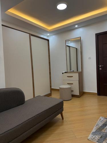 a living room with a couch and a mirror at Cascadia Hotel Apartments by GF Greenland in Kigali