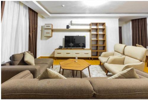 a living room with couches and a flat screen tv at Cascadia Hotel Apartments by GF Greenland in Kigali