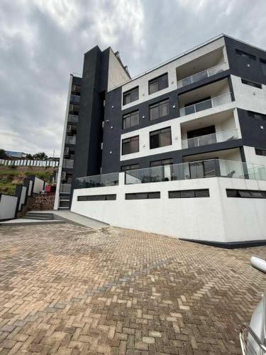 a large building with a brick driveway in front of it at Cascadia Hotel Apartments by GF Greenland in Kigali
