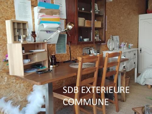 un bureau dans une cuisine avec une lampe et des chaises dans l'établissement Le laboratoire shabby chic de la parfumerie du manoir, à Chavagne