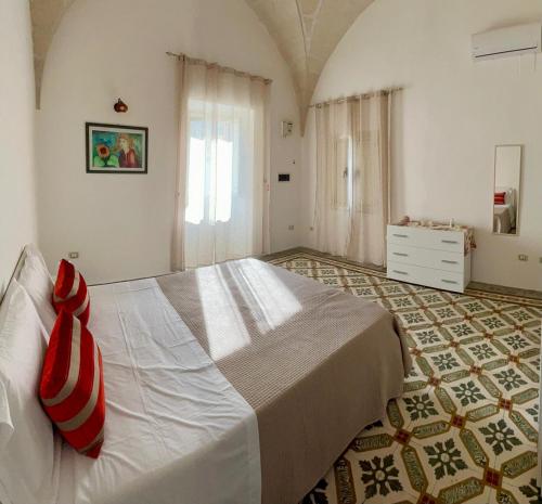 a bedroom with a large white bed with red pillows at Gioem in Botrugno