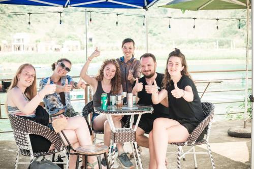 a group of people sitting at a table at Green Riverside Cosy Home in Bố Trạch