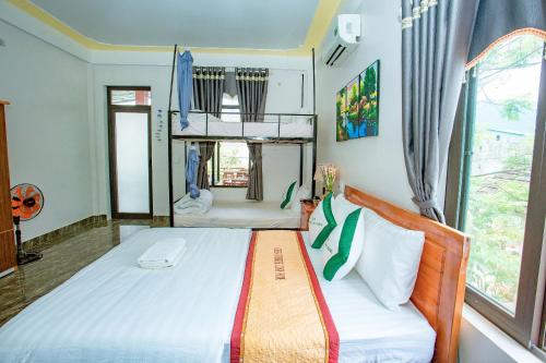a bedroom with a bed and a large window at Green Riverside Cosy Home in Bố Trạch