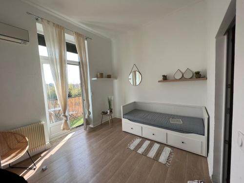 une chambre avec un lit et une grande fenêtre dans l'établissement Beautiful T1 Bordeaux apartment with balcony, à Talence