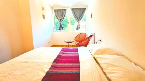 a bed in a room with a window and a rug at -Parcheggio Privato-Riscaldamento Pavimento-WiFi- zona OSPEDALE-CENTRO "COZY PANoRAMA" in Trento