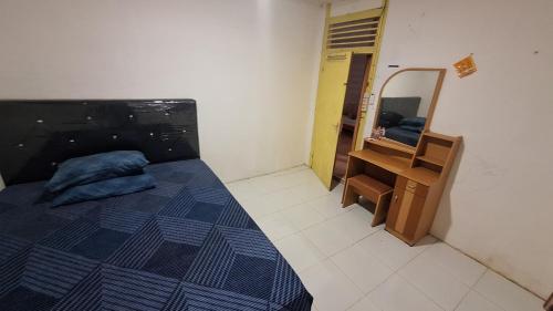 a bedroom with a bed and a dresser and a mirror at 88HappyHomestay in Luwuk