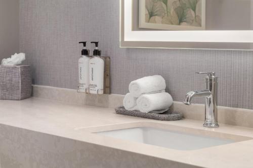 a bathroom counter with a sink with towels on it at EVEN Hotel Orlando International Airport by IHG in Orlando