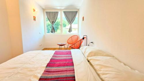 a bed in a room with a window and a rug at PARCHEGGIO GRATUITO ZONA OSPEDALE panoramico, tranquillo, nel verde in Trento