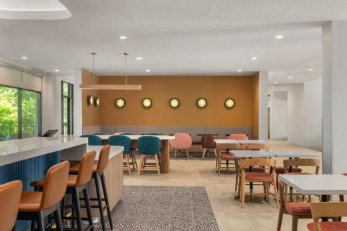 a dining room with tables and chairs at EVEN Hotel Orlando International Airport by IHG in Orlando
