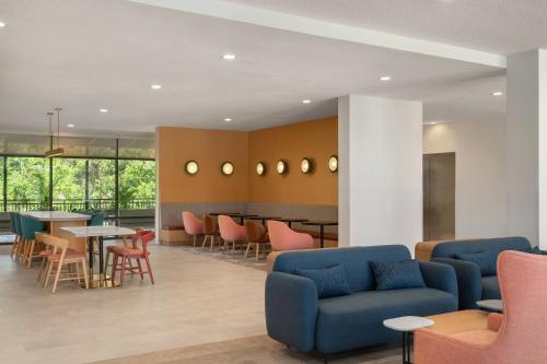 a lobby with blue chairs and tables and a bar at EVEN Hotel Orlando International Airport by IHG in Orlando