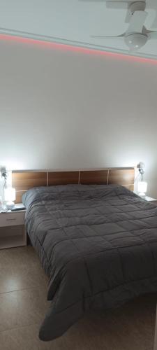 a bedroom with a large bed and a white wall at Apartalux San Pedro Sol in San Pedro del Pinatar