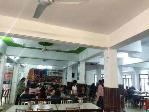 a group of people sitting at tables in a restaurant at Sheetal Restaurant in Mussoorie