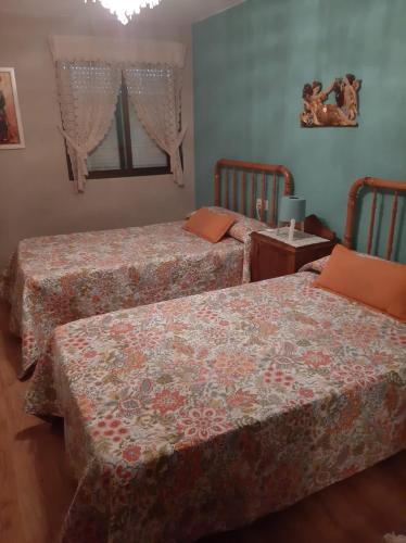 Un dormitorio con dos camas y una mesa. en Medulillas de Yeres, en Yeres
