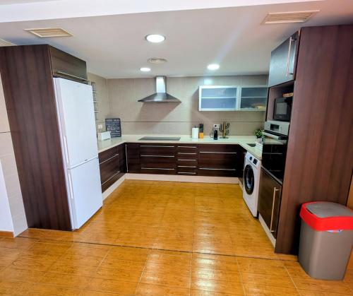 a kitchen with brown cabinets and a white refrigerator at Vacaciones tierra y mar Apartamento en el centro in El Campello