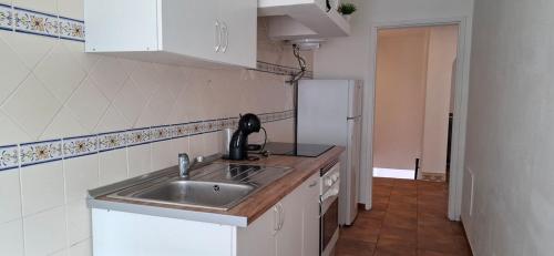 a kitchen with a sink and a refrigerator at Casa São Pedro by Portus Alacer in Sousel