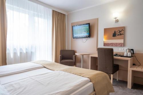 a hotel room with a bed and a desk at Pensjonat Carmen in Szklarska Poręba