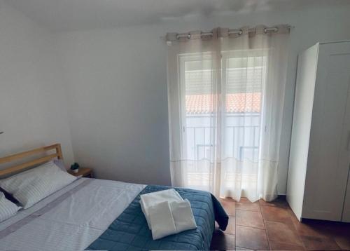 a bedroom with a bed and a large window at Casa São Pedro by Portus Alacer in Sousel