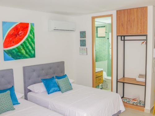 a bedroom with a bed and a painting of a watermelon at Salinas del Mar Suite in Santa Marta