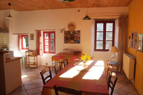 Una cocina y un comedor con mesa y sillas. en Gîte du Grand Sourel, sa vue et son jardin, en Moissac-Vallée-Française