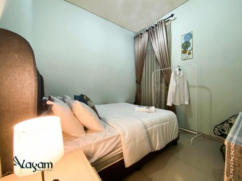 a bedroom with a bed with white sheets and pillows at Alayam Villa Padalarang near whoosh, wahoo waterworld & ikea in Padalarang