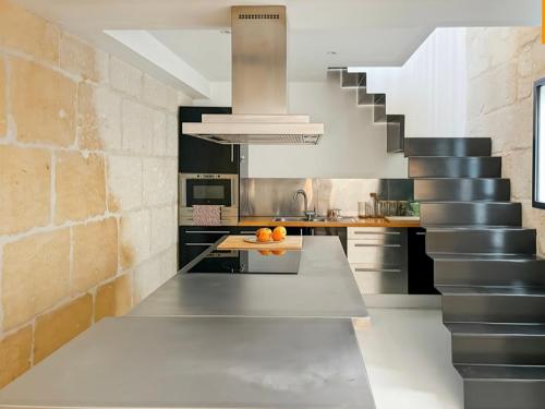 une cuisine avec un escalier et un comptoir avec des oranges dessus dans l'établissement Maison du couvent, à Arles