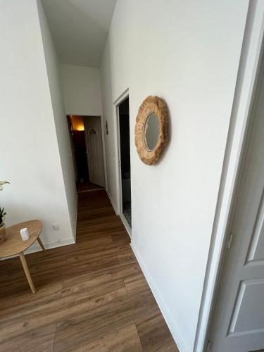 un couloir avec des murs blancs et une couronne sur un mur dans l'établissement Beautiful apartment Bordeaux Bagatelle, à Talence