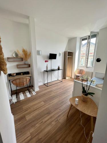 Il comprend un salon doté de murs blancs et de parquet. dans l'établissement Beautiful apartment Bordeaux Bagatelle, à Talence