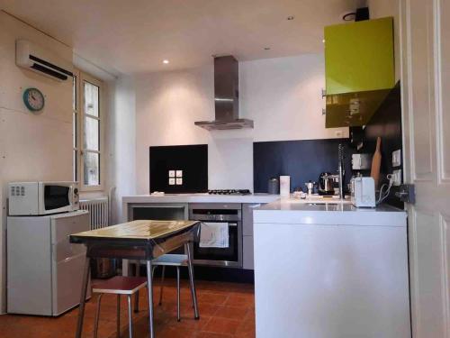 a kitchen with a table and a small kitchen with green cabinets at Appartement 84m2 avec terrasse in Crest