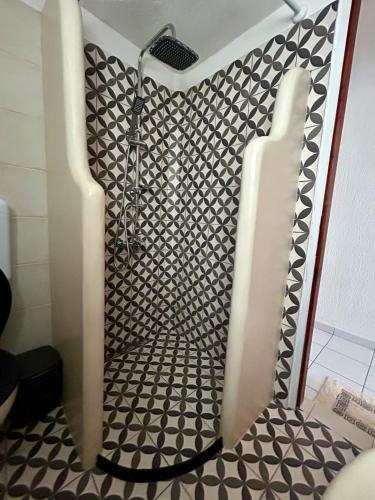 a shower in a bathroom with a black and white pattern at SK studios & apartments in Neo Klima