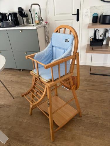 a wooden rocking chair sitting in a kitchen at Studio chic et cocon proche de Disney in Lagny