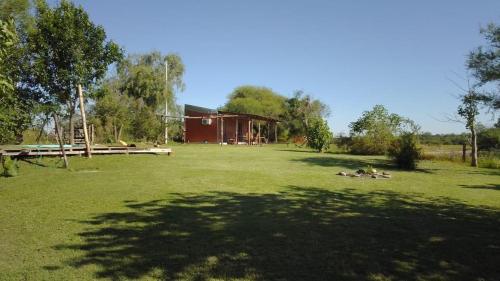 a group of people in a field in front of a barn at Cabaña LA BALSA in Villa Urquiza