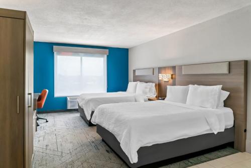 a hotel room with two beds and a window at Holiday Inn Express Lapeer by IHG in Lapeer