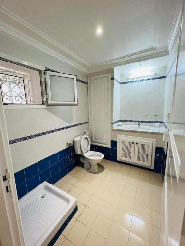 a blue and white bathroom with a toilet and a window at 2-bedroom apartment in Yasmine Hammamet in Yasmine