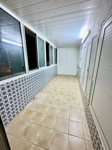 an empty room with a tile floor and windows at 2-bedroom apartment in Yasmine Hammamet in Yasmine