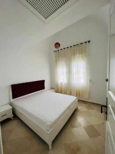 a bedroom with a white bed and a window at 2-bedroom apartment in Yasmine Hammamet in Yasmine