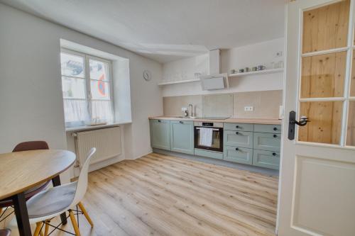 a kitchen and dining room with a table and chairs at Suite Kelnhof Patio - Cozy Riverside Apartment in Küssaberg