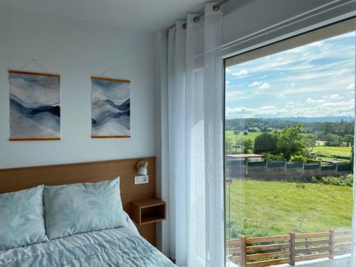 a bedroom with a bed and a large window at Casa da Marola in Zas