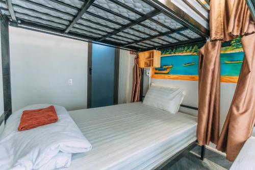 a bedroom with two beds and a painting on the wall at Green Riverside Cosy Home in Bố Trạch