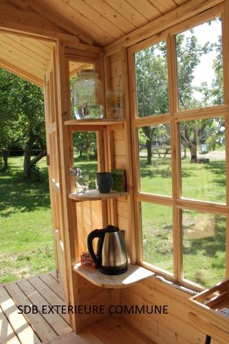 Ce chalet en bois dispose de fenêtres et d'une bouilloire. dans l'établissement La cabine du capitaine 4m² - SDB partagée extérieure, à Chavagne