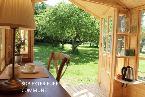 une pièce avec une table dans un hangar avec un jardin dans l'établissement La cabine du capitaine 4m² - SDB partagée extérieure, à Chavagne