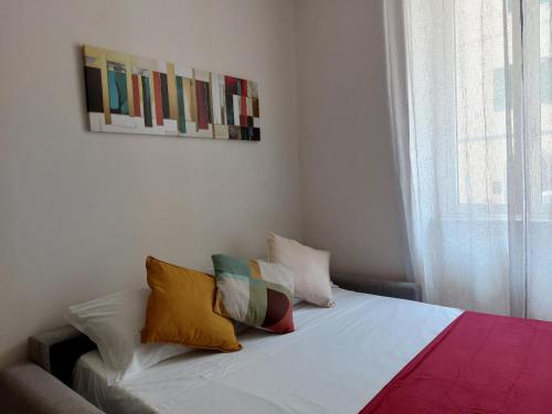 a bedroom with a bed with colorful pillows on it at A 50 passi dal lago - Affitti Brevi Italia in Capodimonte
